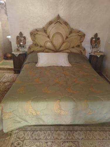 - une chambre avec un grand lit et une grande tête de lit dans l'établissement Firma lfassiya, à Dar SaÃ¯d Ben Hajj