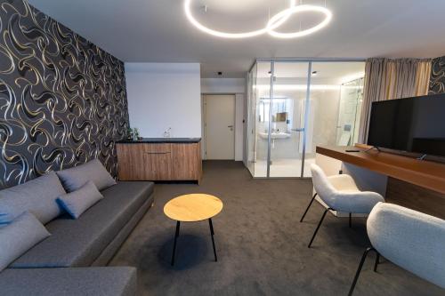 a living room with a couch and a flat screen tv at Hotel Zemplín in Trebišov