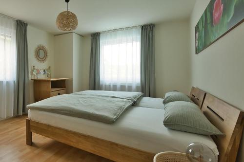 une chambre avec un grand lit devant une fenêtre dans l'établissement Adesso - Ferienwohnung im Schwarzwald, à Leinstetten