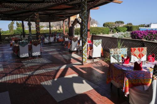 a patio with a table and chairs under a pavilion at Blend Elphistone Resort Marsa Alam in Abu Dabab
