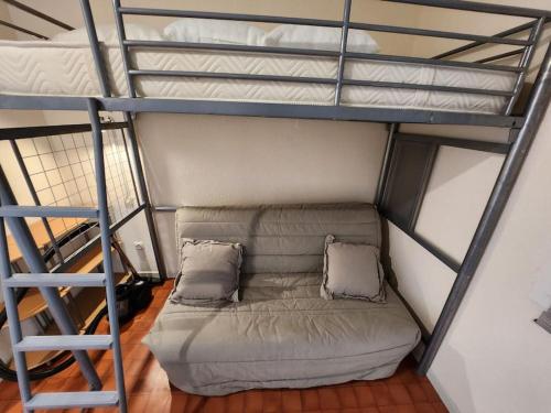 a couch sitting under a bunk bed with a ladder at Joli T2 Centre port résidence Quai d'Honneur in Cap d'Agde