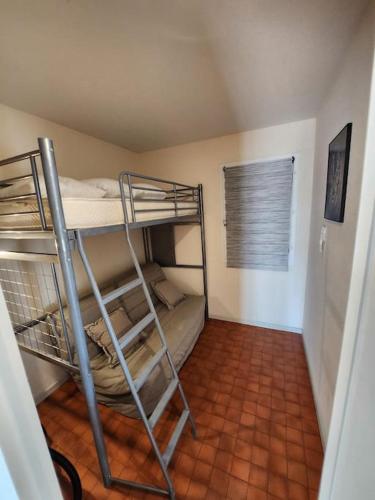 Cette chambre est dotée de carrelage et de 2 lits superposés. dans l'établissement Joli T2 Centre port résidence Quai d'Honneur, au Cap d'Agde