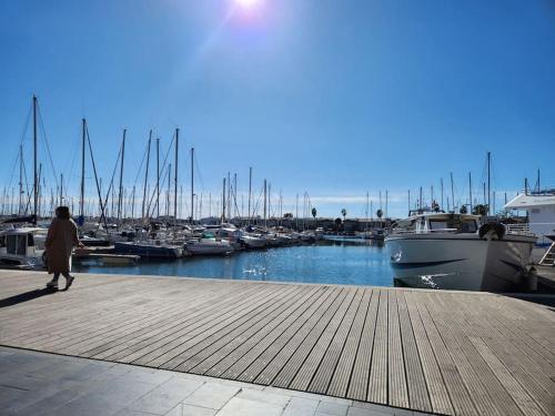 una mujer caminando por un puerto deportivo con barcos en Joli T2 Centre port résidence Quai d'Honneur, en Cap d'Agde