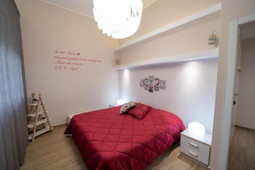 a bedroom with a red bed with a red comforter at Holidays Lecce in Lecce