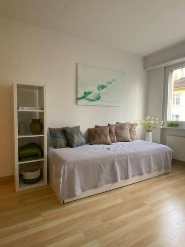 a white bedroom with a bed in a room at Gemütliche Wohnung Nähe Rhein in Basel
