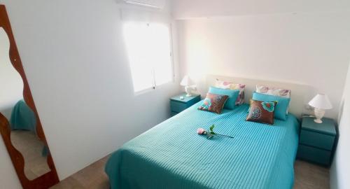 a bedroom with a blue bed with pillows at Siesta in Hospitalet de l'Infant