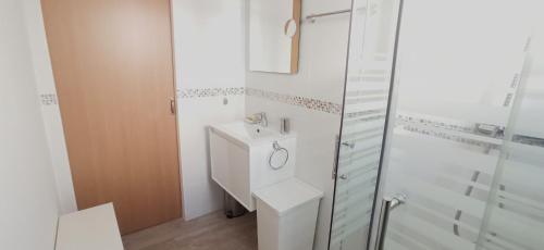 a white bathroom with a sink and a shower at Siesta in Hospitalet de l'Infant