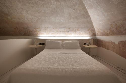a small bedroom with a bed and two tables at Dimora San Giuseppe in Lecce