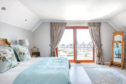 a bedroom with a bed and a large window at 3 Bedroom Hilltop Home with Spectacular Views in Cape Town