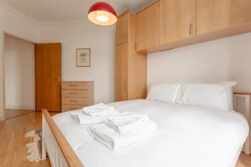 um quarto com uma cama branca com duas toalhas em Large & Central 2BD Flat - Tower Hill em Londres