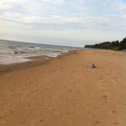 a beach with a rock in the sand at Miera osta atpūtai Skultē Garāža in Skulte