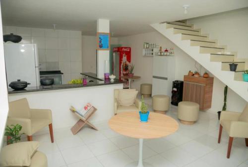 a living room with a table and a staircase at Pousada Serra Mares in Ilhéus