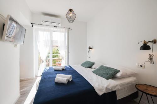 1 dormitorio con 1 cama grande con sábanas y almohadas azules en Zaratino rooms, en Zadar