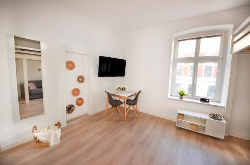 een witte woonkamer met een tafel en stoelen bij Apartmenthaus Fritz Reuter in Schwerin