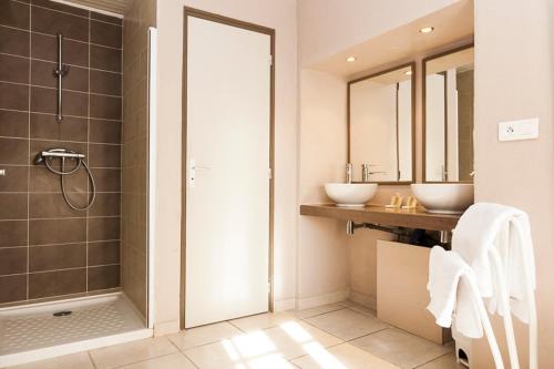 a bathroom with two sinks and a shower at Hôtel Les Magnanarelles in Maussane-les-Alpilles