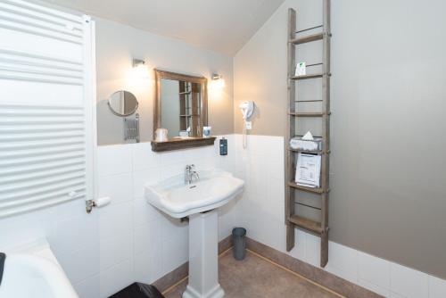 a bathroom with a sink and a shelf at Le Gingko - Hotel du Golf Parc Robert Hersant in La Chaussée-dʼIvry