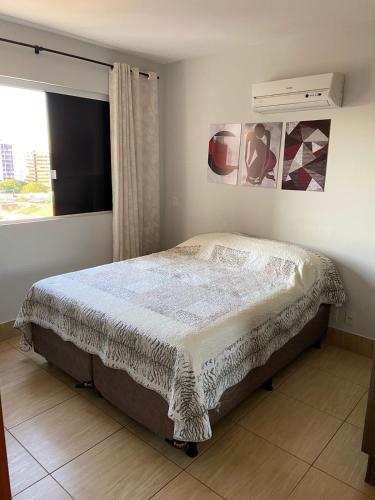 a bed in a bedroom with a window at Apartamento no Fiori Prime in Caldas Novas