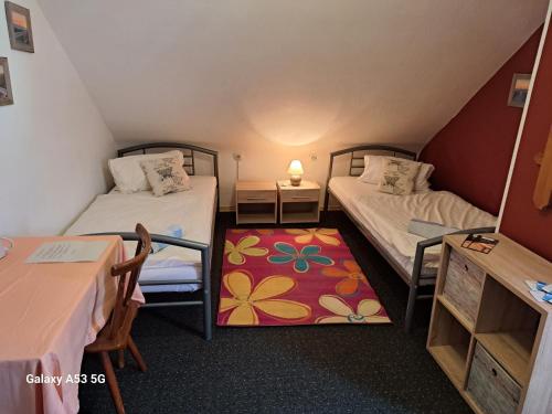 Cette petite chambre comprend deux lits et une table. dans l'établissement pension sonne, à Ulm