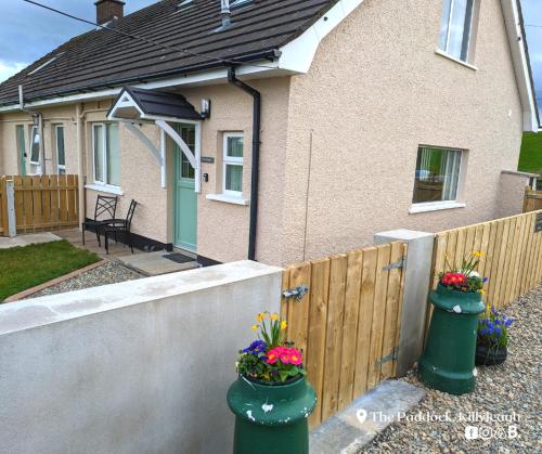 a house with two flower pots in front of a fence at The Paddock in Killyleagh