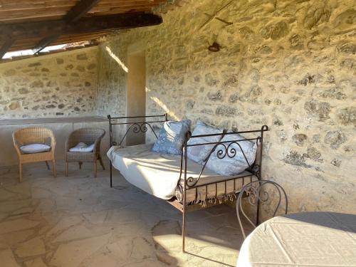ein Schlafzimmer mit einem Bett in einer Steinmauer in der Unterkunft La Magnanerie en Provence in Niozelles