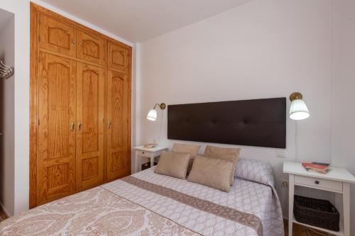1 dormitorio con 1 cama y un gran armario de madera en Tolox 2 en Tolox
