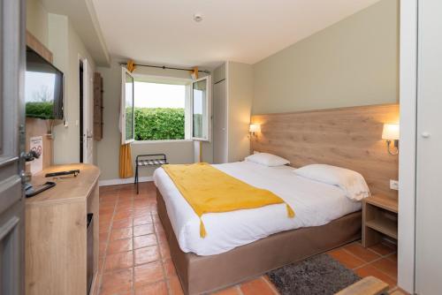a bedroom with a large bed and a window at Le Gingko - Hotel du Golf Parc Robert Hersant in La Chaussée-dʼIvry