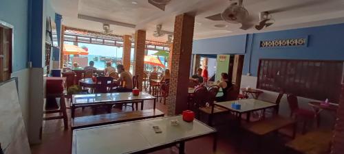 restauracja ze stołami i krzesłami oraz osobami w niej w obiekcie Family Guesthouse w mieście Koh Rong