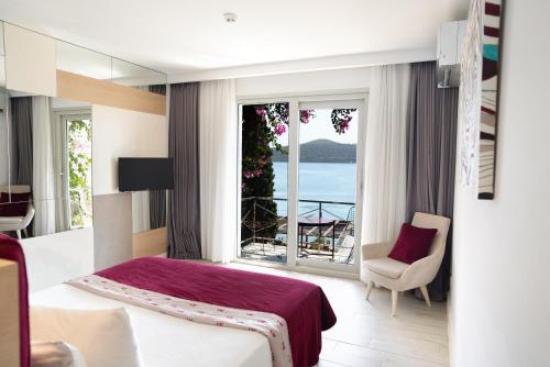 a bedroom with a bed and a view of the ocean at No81 Hotel in Golturkbuku