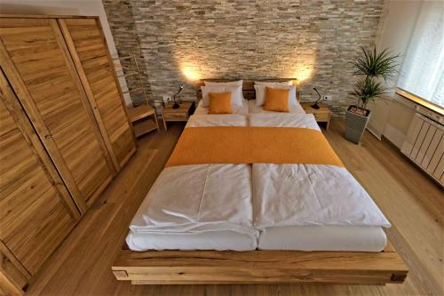ein großes Bett in einem Zimmer mit Ziegelwand in der Unterkunft Alb Fe Wo in Sankt Johann