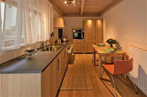 eine Küche mit einem Waschbecken und einem Holztisch in der Unterkunft Alb Fe Wo in Sankt Johann