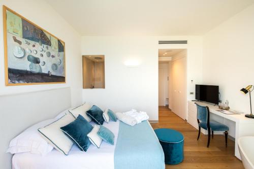 a living room with a white couch with blue pillows at Unìco Boutique Hotel d'Arte in Mondello