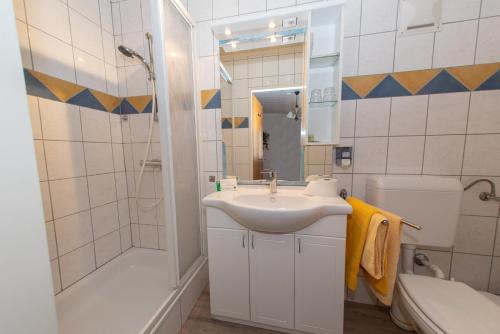 a bathroom with a sink and a shower and a toilet at Gästehaus-Pension Familie Dwars in Spitz