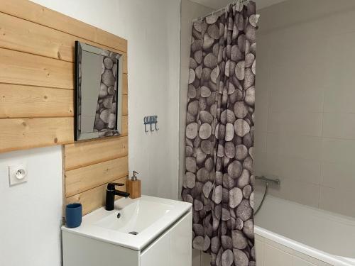 ein Bad mit einem Waschbecken und einem Duschvorhang in der Unterkunft Maison CALAIS centre ville L in Calais