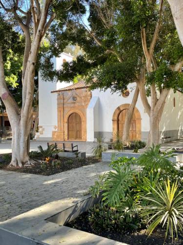 a building with a clock on it with trees at Casa Palmera in Costa de Antigua