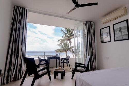 a bedroom with a room with a view of the ocean at Bieshu Beach Hive in Habaraduwa