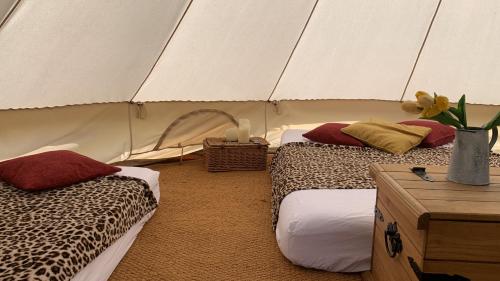 a room with two beds in a tent at Home Farm Radnage Glamping Bell Tent 3, with Log Burner and Fire Pit in Radnage