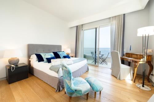a bedroom with a large bed with a view of the ocean at Unìco Boutique Hotel d'Arte in Mondello
