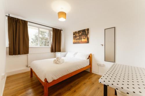 um quarto com uma cama com um urso de peluche em Wesferry beds to stay em Londres