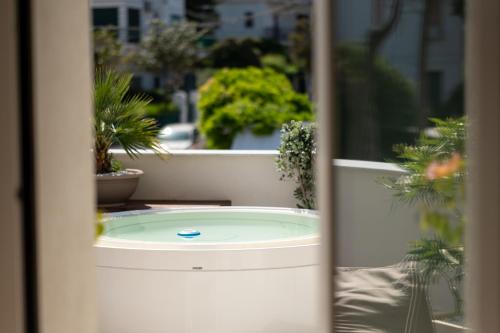 a window view of a garden with potted plants at Unìco Boutique Hotel d'Arte in Mondello