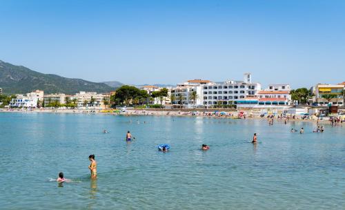 a group of people in the water at a beach at Medplaya Hotel Vistamar Costa Dorada in Hospitalet de l'Infant