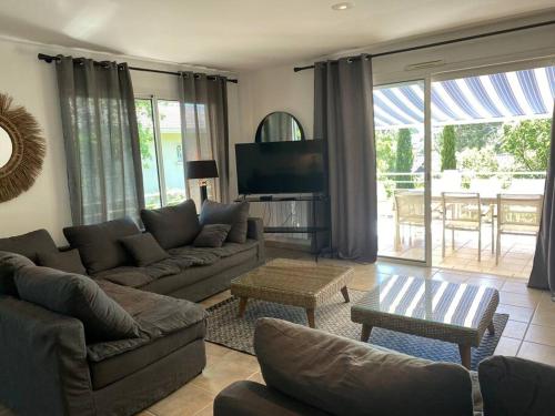 a living room with a couch and a tv at Villa Arethuse - Pyla sur Mer in Pyla-sur-Mer