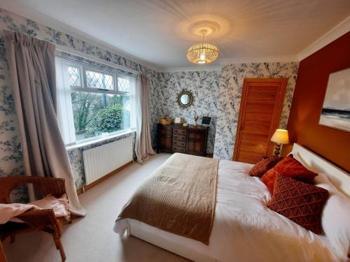 um quarto com uma cama grande e uma janela em - The Holly Tree House - em Bushmills
