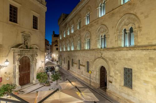 a group of umbrellas in a courtyard of a building at Fiveplace Design Suites & Apartments in Trapani