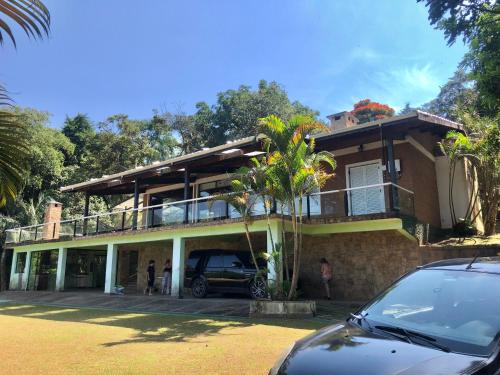 a house with a car parked in front of it at Chacara pé na agua represa de Mairiporã in Mairiporã
