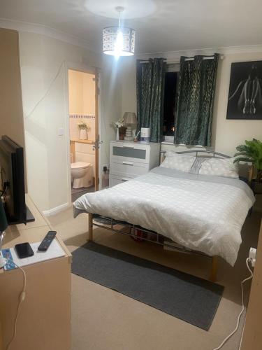 a bedroom with a large bed and a bathroom at Basingstoke by train station in Basingstoke