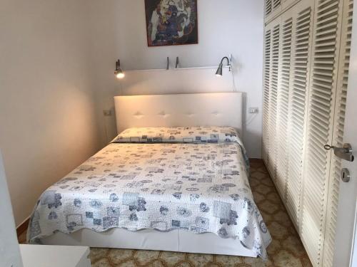 um quarto com uma cama com uma colcha branca em casa fiorella em San Bernardino