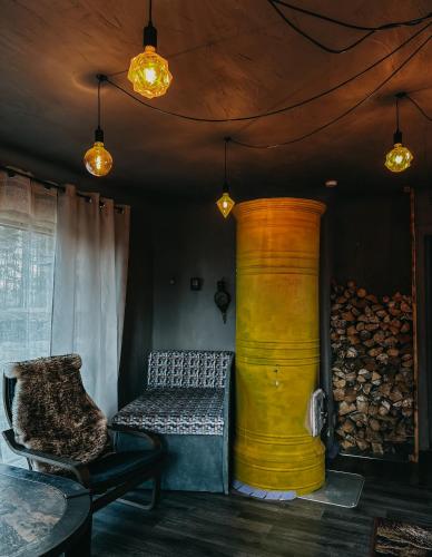 a room with a couch and a yellow barrel at Private Farm Jakuzzi Sauna in the forest in Talsi