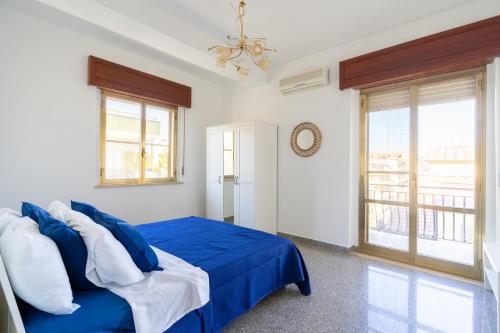 Un dormitorio con una cama azul y una ventana en Casa Ludo, en Soverato Marina