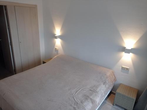 een slaapkamer met een bed en twee lampen aan de muur bij Residencial Xeresa del Monte Solo Familias Serviplaya in Jeresa