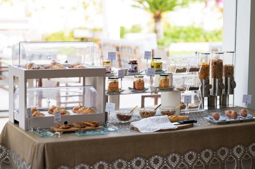 a table with a buffet of pastries and other foods at Unìco Boutique Hotel d'Arte in Mondello